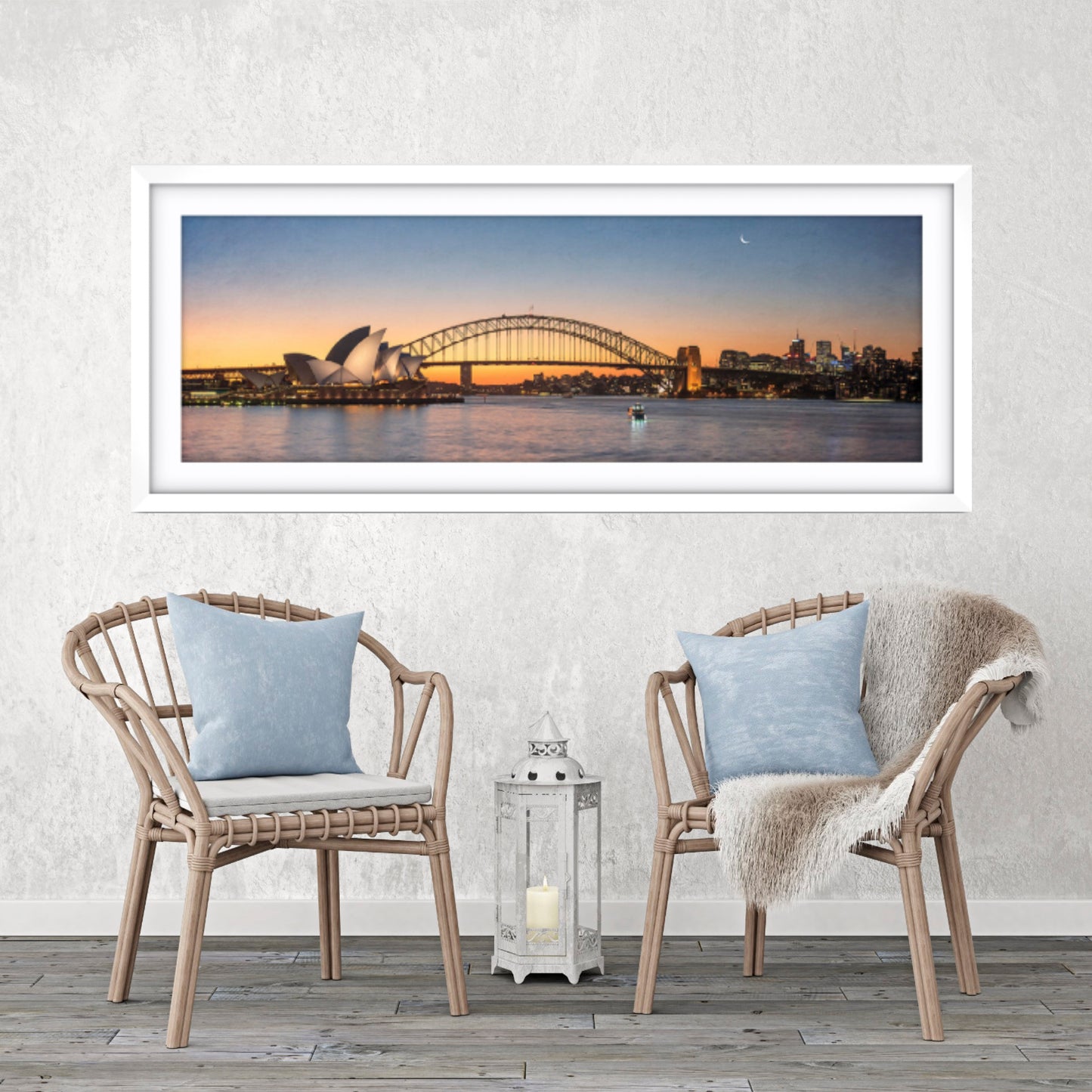 Framed artwork of a cityscape with a bridge and Opera House, displayed above two chairs with cushions.