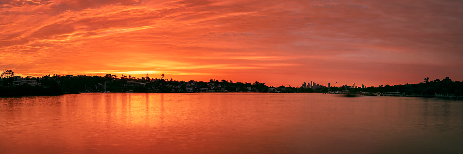 Color long exposure photograph of Cabarita Point wharf Parramatta River dawn ochre light ethereal ferry motion molten reflections