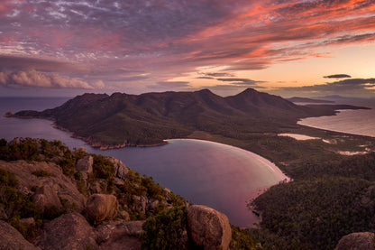 Wineglass Bay Tasmania from Mt Amos summit with golden sunset light over crescent beach and turquoise water