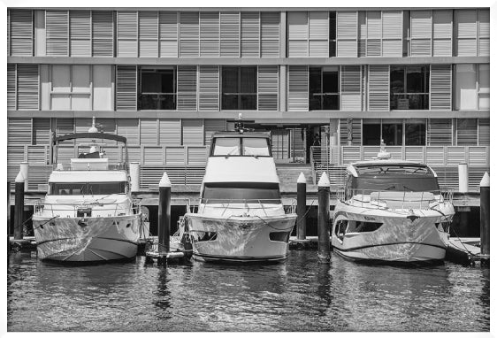 Three boats docked at a marina with a building in the background