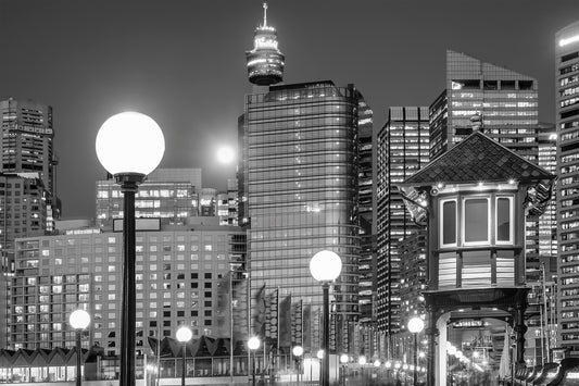 Black and white photograph of full moon rising over Pyrmont Sydney Harbour waterfront skyline at dusk