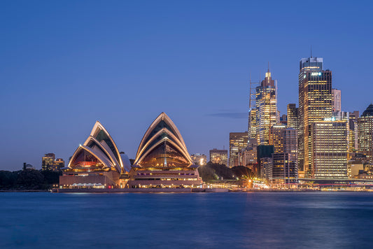 Color long exposure panoramic photograph of Sydney Opera House at dusk with smooth harbour water reflections