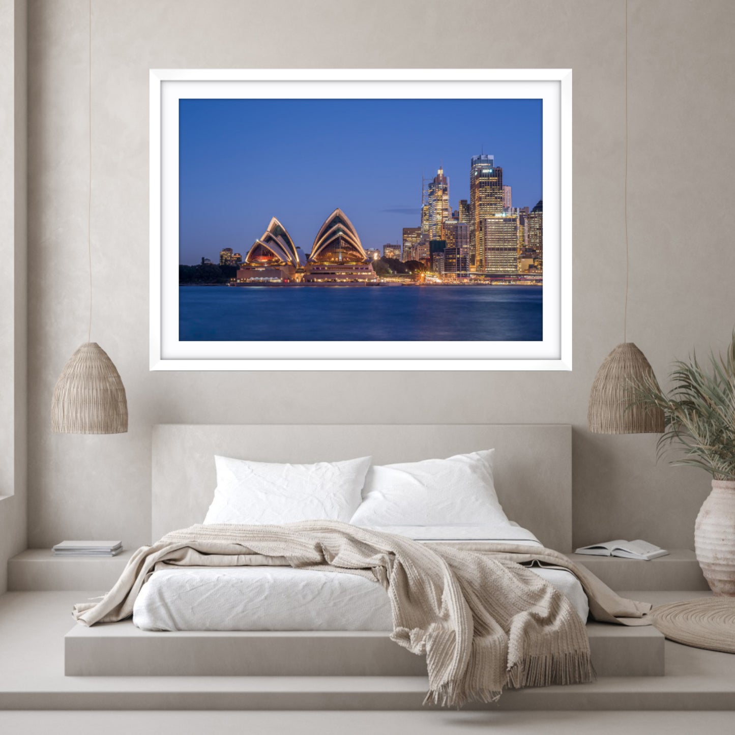 Framed photograph of a city skyline above a bed in a bedroom.