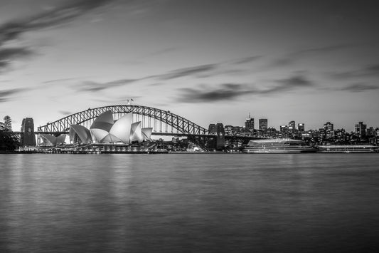 Black and white photograph of Manly ferry approaching Circular Quay with cruise vessel on Sydney Harbour