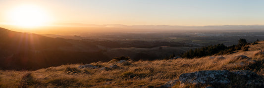 Queenstown New Zealand golden hour sunset panorama with rocky foreground overlooking town